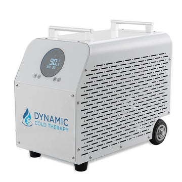 A portable cold therapy chiller machine by Dynamic Cold Therapy, featuring a white aluminum body, a digital temperature display on the front panel and caster wheels.