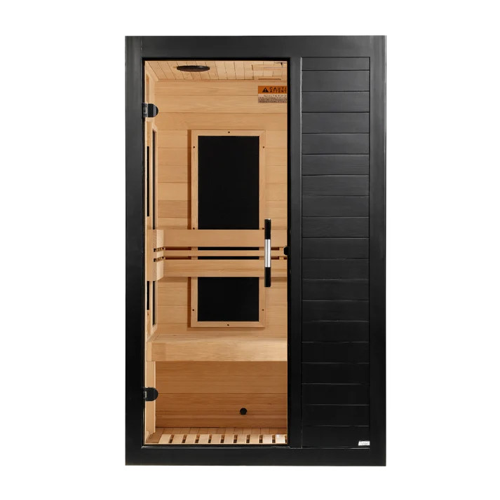 A modern single-door infrared sauna with a black exterior frame and tempered glass door, featuring light natural wood interior walls, benches, and ceiling.