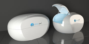 Two premium white Dreampod Home Float Plus sensory deprivation tank pods in an indoor setting on tiles.
